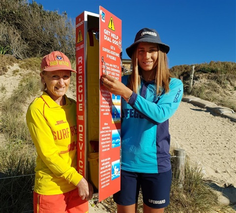 Lifeguards opening a rescue tube storage box