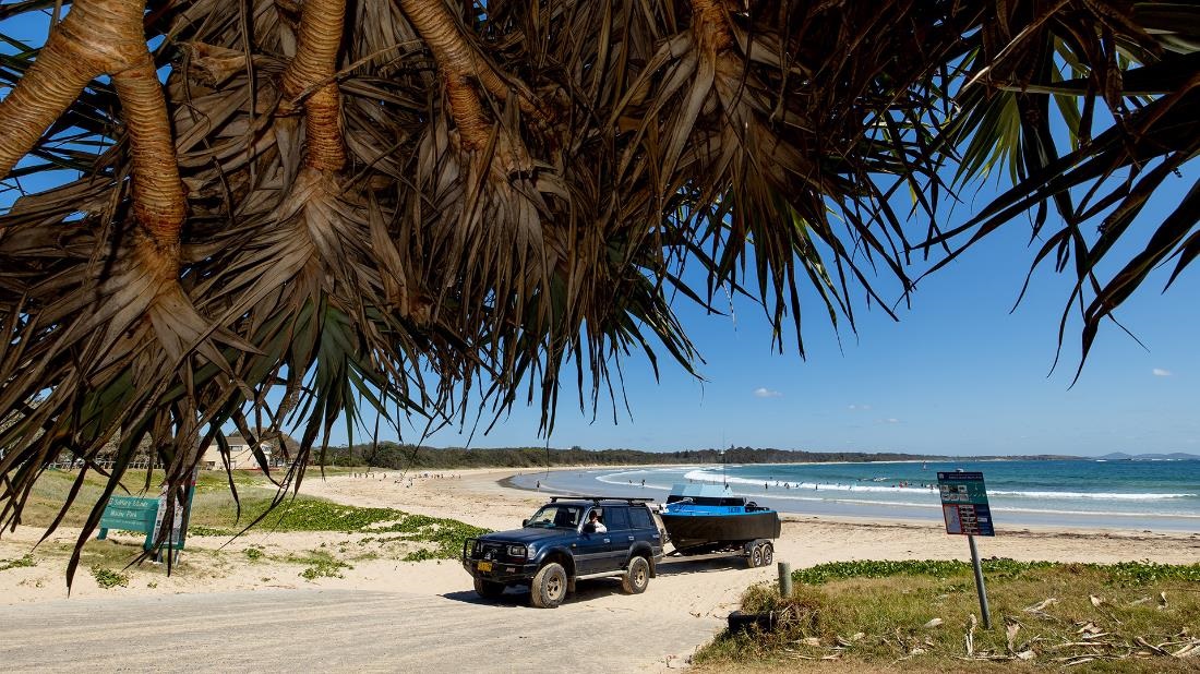 4WD driving a boat onto Woolgoolga Beach from the boat ramp