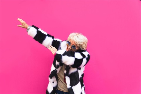 Older woman throws a pose in a funky coat